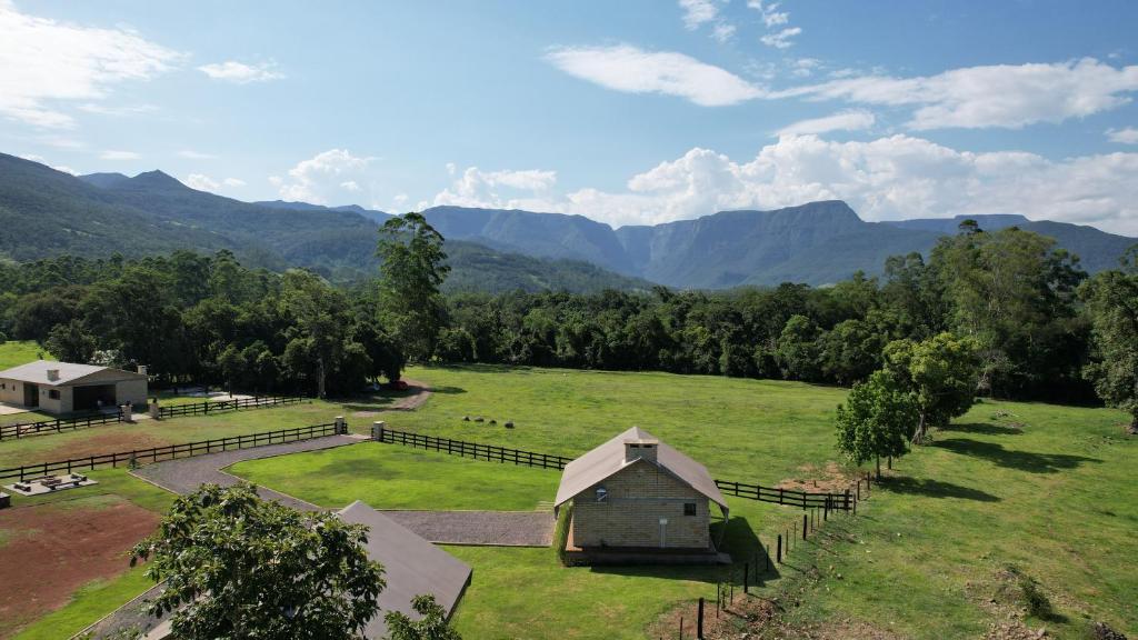an aerial view of a farm with mountains in the background at Vicença Glamping in Praia Grande