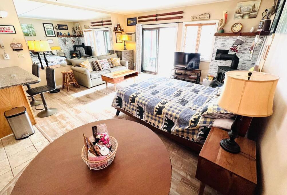 ein Schlafzimmer mit einem Bett und ein Wohnzimmer in der Unterkunft Attitash Mountain Village Studio - Slope View - Ski - NEWLY RENOVATED in Bartlett