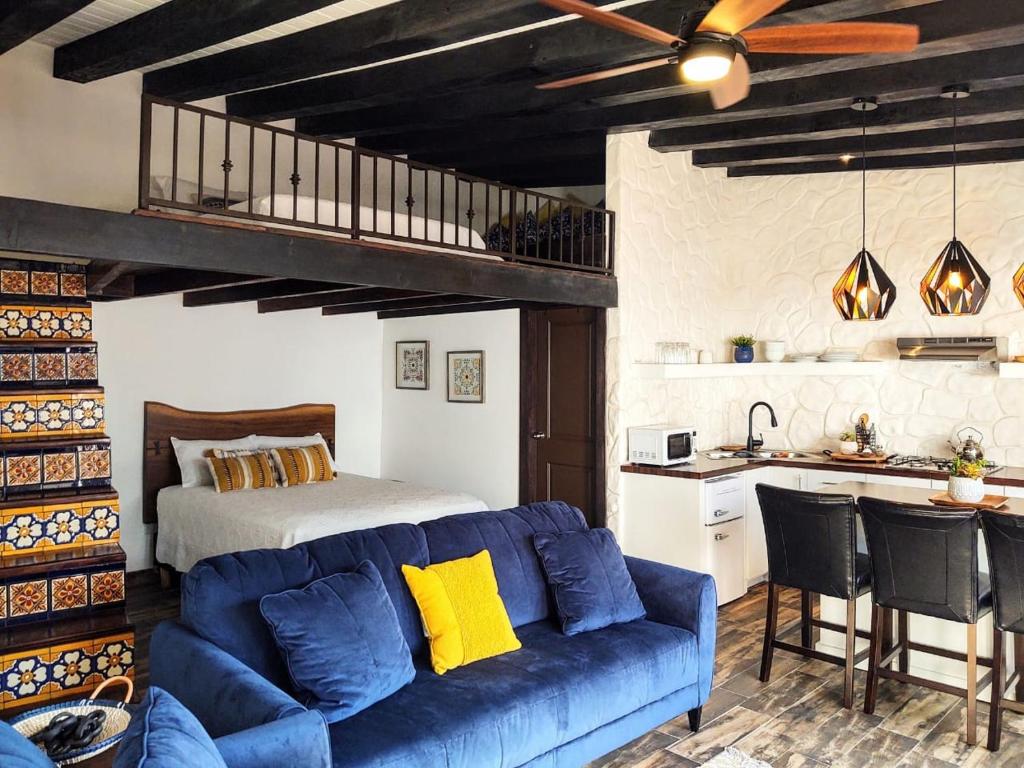 a living room with a blue couch and a bed at Hacienda El Galeon in Ensenada