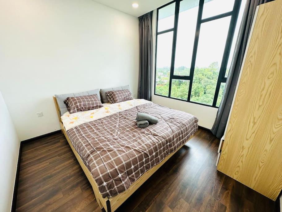 a bedroom with a bed and a large window at Kuching BDC Saradise Rex Apartment in Kuching