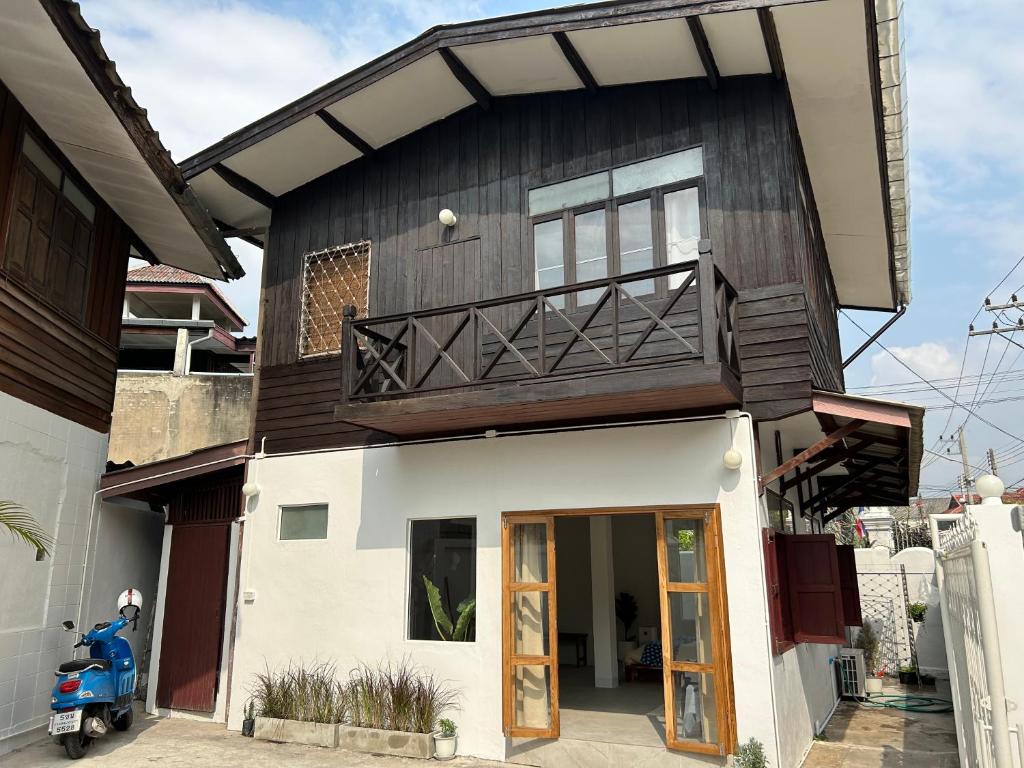 a house with a scooter parked in front of it at Cozy villa in Chiangmai old town in Chiang Mai