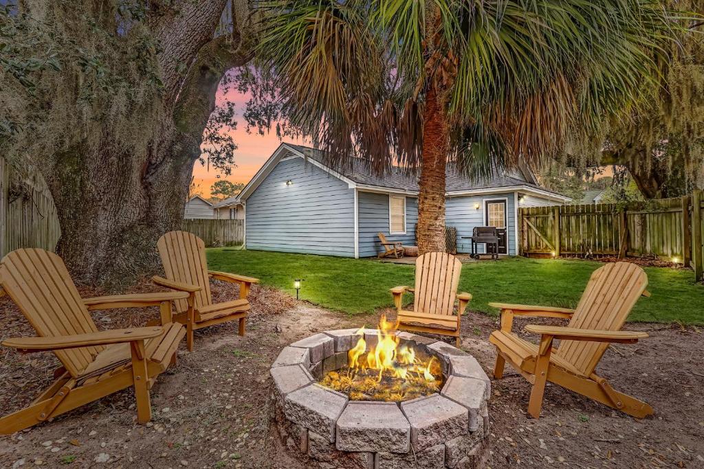 un patio trasero con 3 sillas y una hoguera en Wilmington Island Retreat, en Savannah