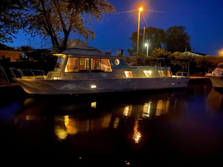 a boat sitting in the water at night at The Lily Pad Boatel Houseboat in Savanna