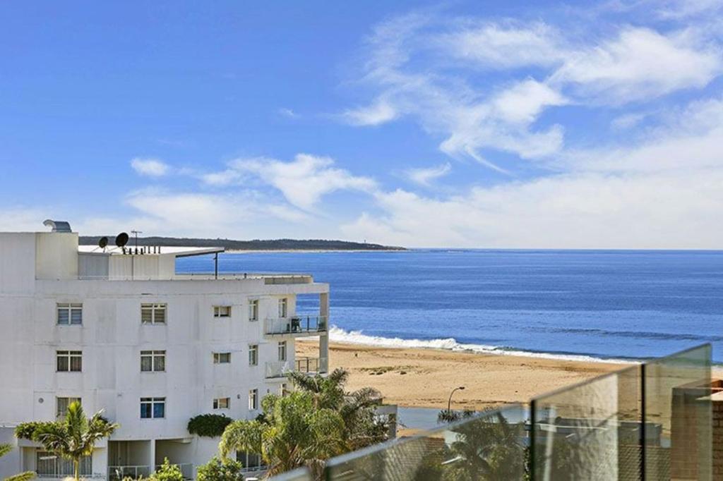 a view of a beach and a building and the ocean at Sandy Cove Apartment The Entrance 22 in The Entrance