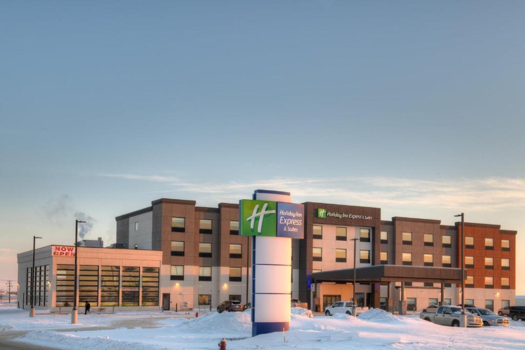 um edifício com um sinal em frente dele na neve em Holiday Inn Express & Suites - Moose Jaw, an IHG Hotel em Moose Jaw