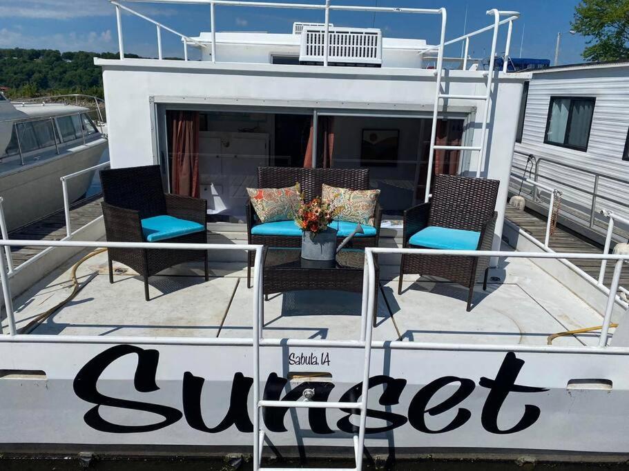 a boat with chairs and tables on a dock at Unique and Serene Sunset Houseboat for 4 in Savanna