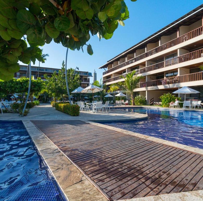 una piscina resort con un hotel en el fondo en Flat no Nannai Residence, en Porto de Galinhas
