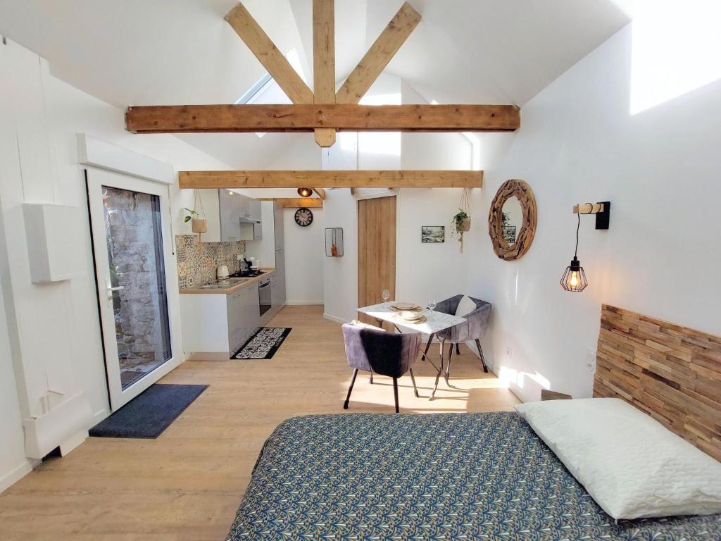 um quarto com uma cama e uma mesa num quarto em Charming granite stone cottage between land and sea, in St Pol de Leon em Saint-Pol-de-Léon
