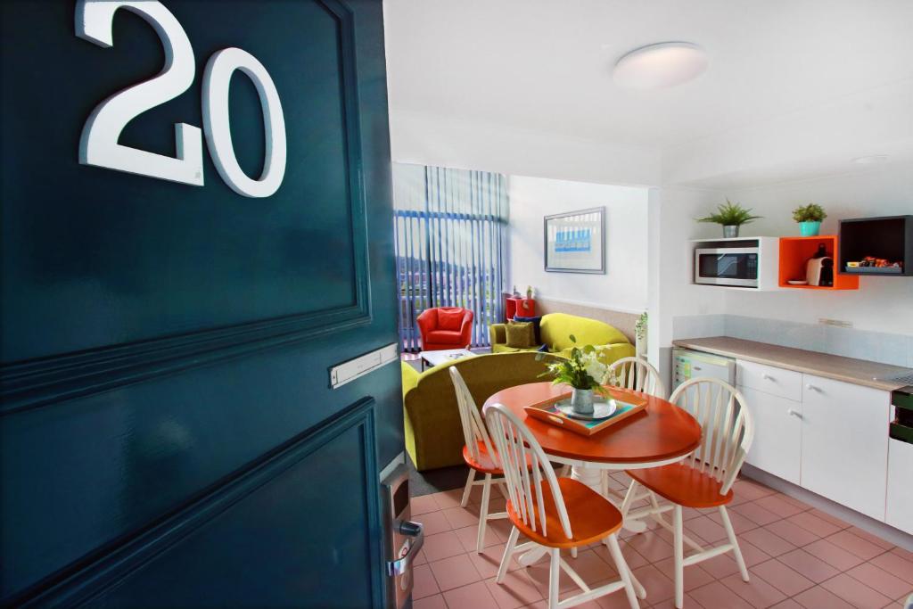 a kitchen and dining room with a table and chairs at Sea Spray Motel - Merimbula in Merimbula