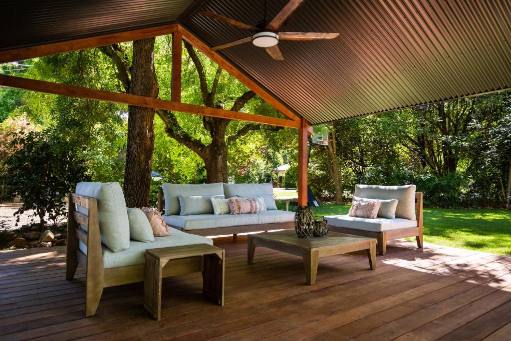 eine Veranda mit 2 Sofas und einem Tisch auf einer Terrasse in der Unterkunft Adina Lodge Holiday Apartments in Bright