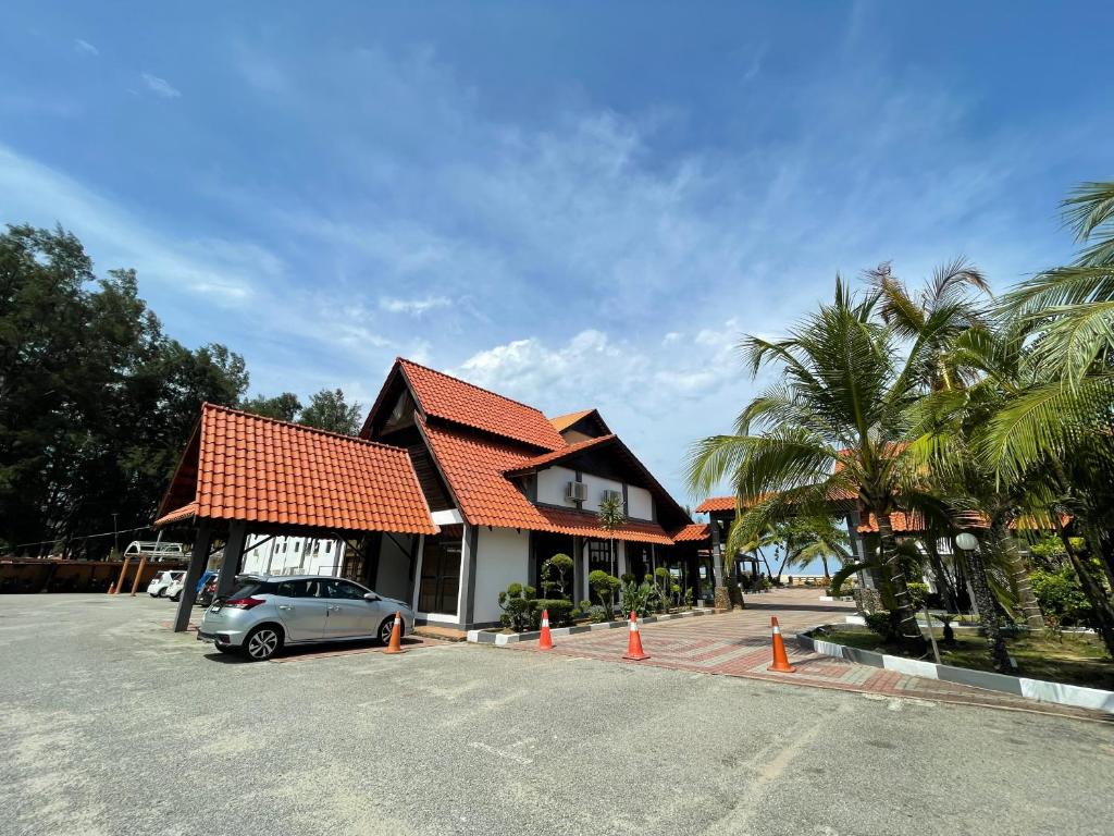 a car parked in a parking lot in front of a house at DSH Batu Burok Beach Resort in Kuala Terengganu