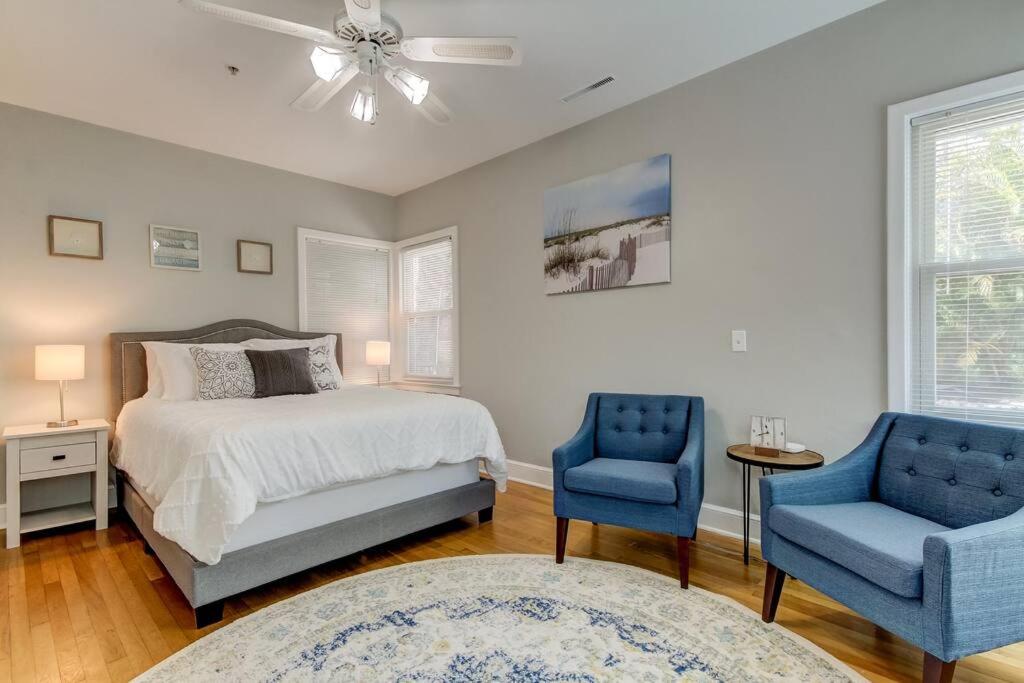 a bedroom with a bed and two blue chairs at Light & Bright! Quaint Downtown Dunedin Bungalow! in Dunedin