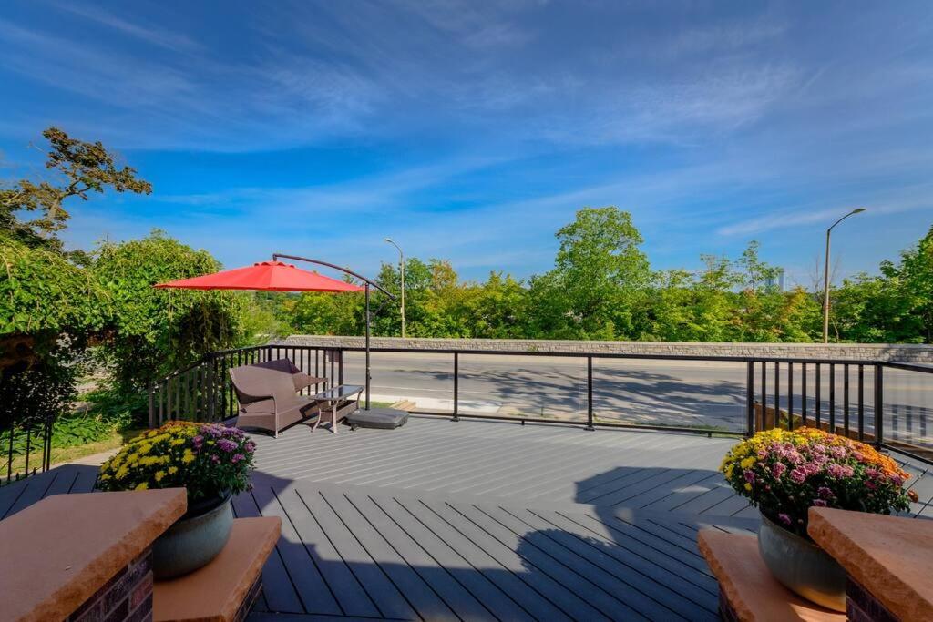 a patio with a chair and an umbrella and flowers at Niagara River&Glenview Home-15MinsWalkToFalls in Niagara Falls