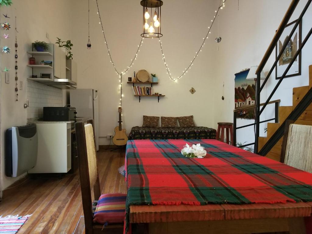 sala de estar con mesa y manta roja y verde en Cute Home en Buenos Aires