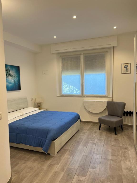 een slaapkamer met een bed, een stoel en een raam bij Affittacamere Vallesanta in Levanto