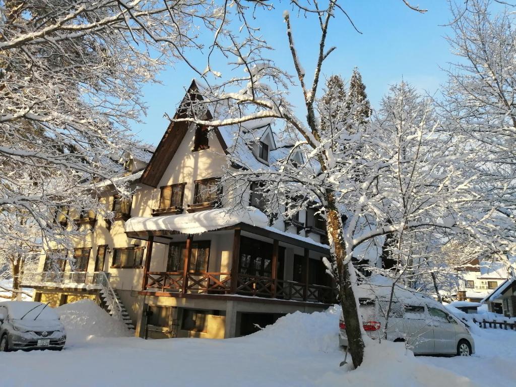 une maison recouverte de neige dans l'établissement Pilot Lodge, à Hakuba