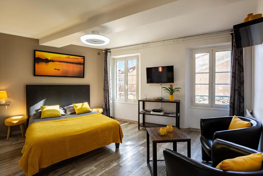 ein Schlafzimmer mit einem gelben Bett und einem Fernseher in der Unterkunft Studi'o Soleil in Cannes