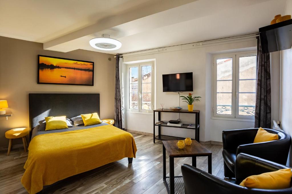 a bedroom with a yellow bed and a tv at Studi'o Soleil in Cannes