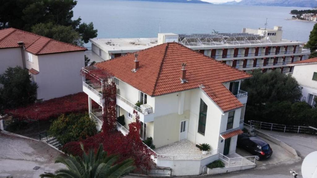 a white house with an orange roof at Apartments Maja 100 from the beach in Podgora
