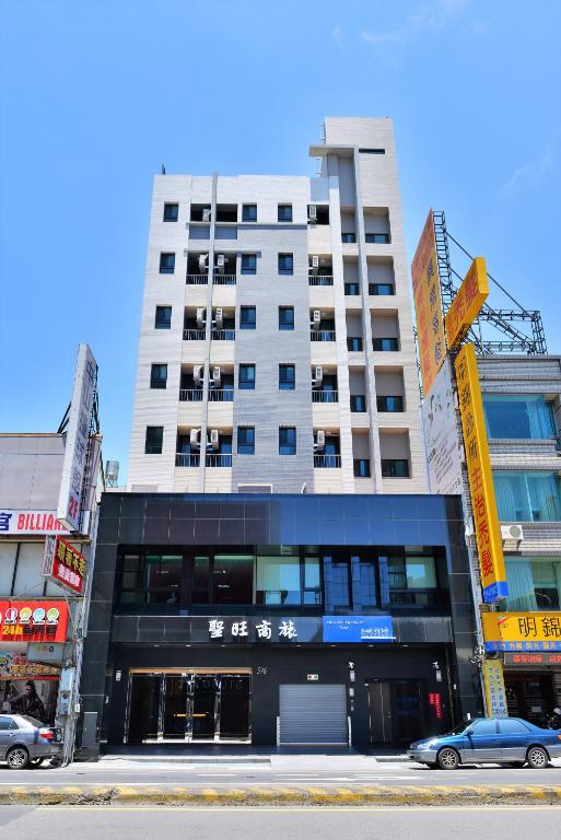 a tall building in the middle of a city at San Juan Easy Stay Inn Tainan in Tainan