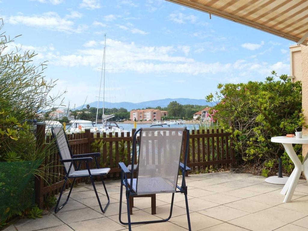 2 chaises et une table sur une terrasse avec un port de plaisance dans l'établissement Studio Climatise avec Terrasse à Saint-Cyprien - Animaux Admis, Parking - FR-1-225D-434, à Saint Cyprien Plage