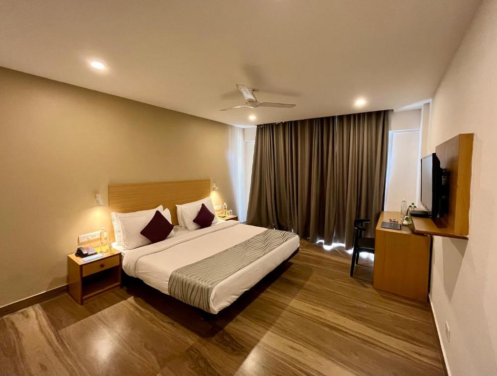 une chambre d'hôtel avec un lit et une télévision dans l'établissement Hotel The Golden Sands, à Calangute