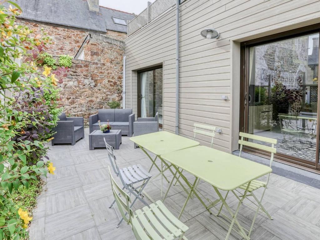 un patio avec une table et des chaises sur un patio dans l'établissement Appartement avec grande terrasse, WIFI, proche port et commerces, Perros-Guirec - FR-1-368-338, à Perros-Guirec