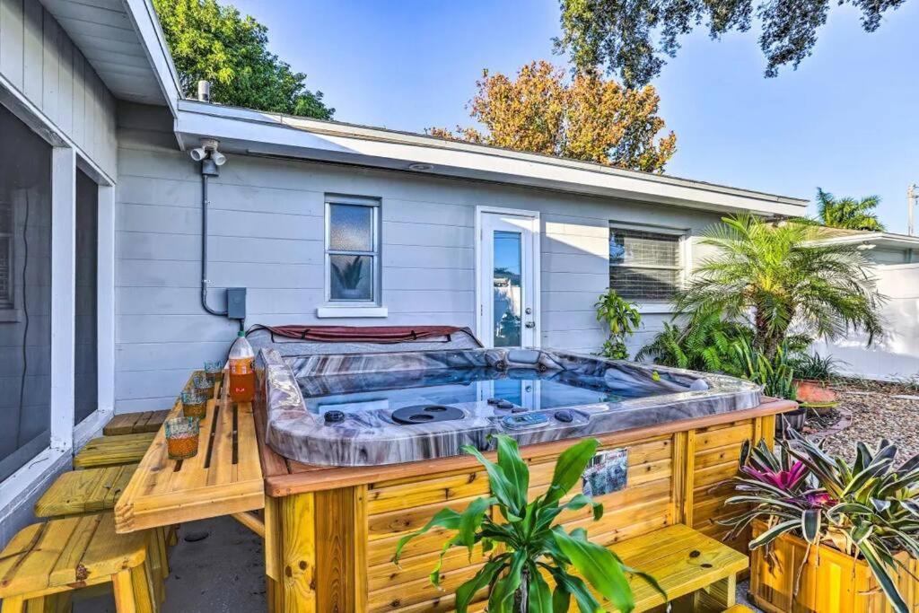 bañera de hidromasaje en una terraza frente a una casa en NEW! Cheerful bungalow with hot tub near beaches en Bay Pines