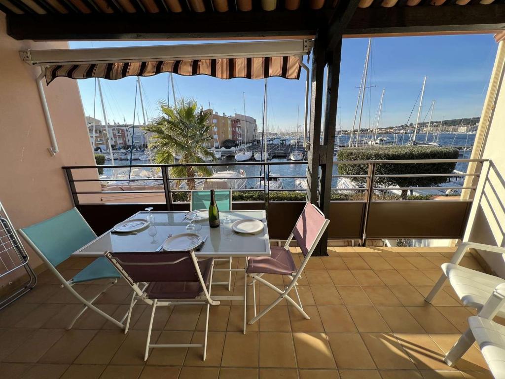 d'une table et de chaises sur un balcon avec vue sur le port. dans l'établissement Studio cabine avec piscine, parking, lave-linge, quartier calme à Cap d'Agde - FR-1-702-39, au Cap d'Agde