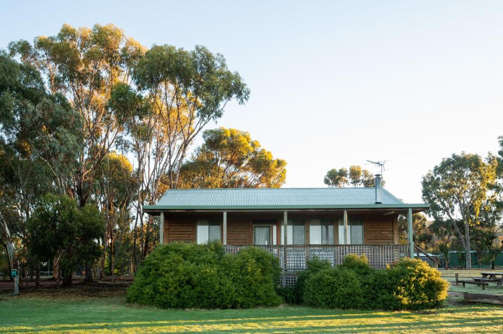 a wooden house with a green roof in a park at Happy Wanderer Holiday Resort The Grampians in Wartook