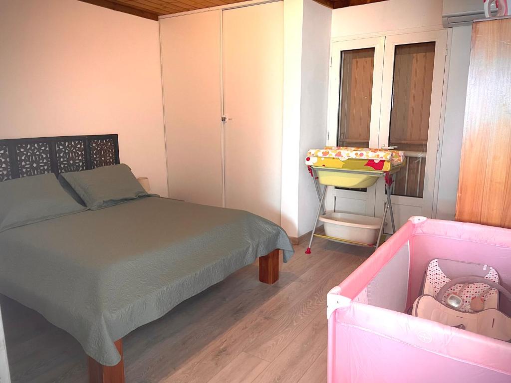 Alambic de Grand Anse في بيتيت ايلي: غرفة نوم بسرير وسرير أطفال ومغسلة