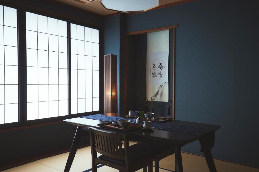 a dining room with a table and a chair and windows at Sui Suwako in Suwa