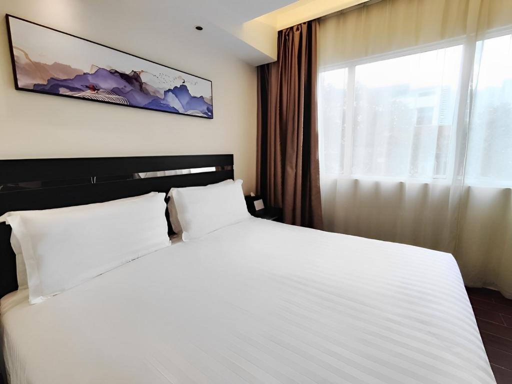 a bedroom with a large white bed and a window at Link Hotel Singapore in Singapore