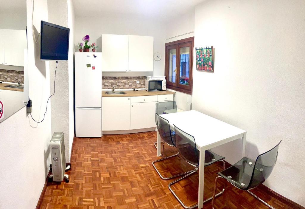 una cucina con tavolo e frigorifero bianco di Apartamento zona Palacio de las Dueñas y las Setas a Siviglia