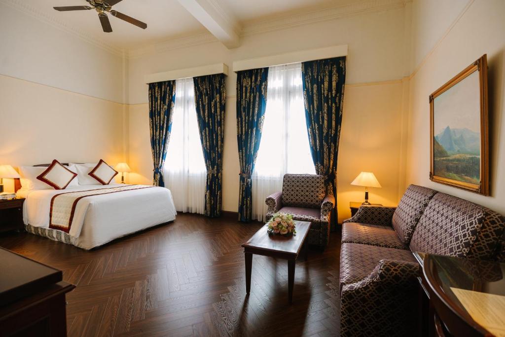 a hotel room with a bed and a couch at Du Parc Hotel Dalat in Da Lat
