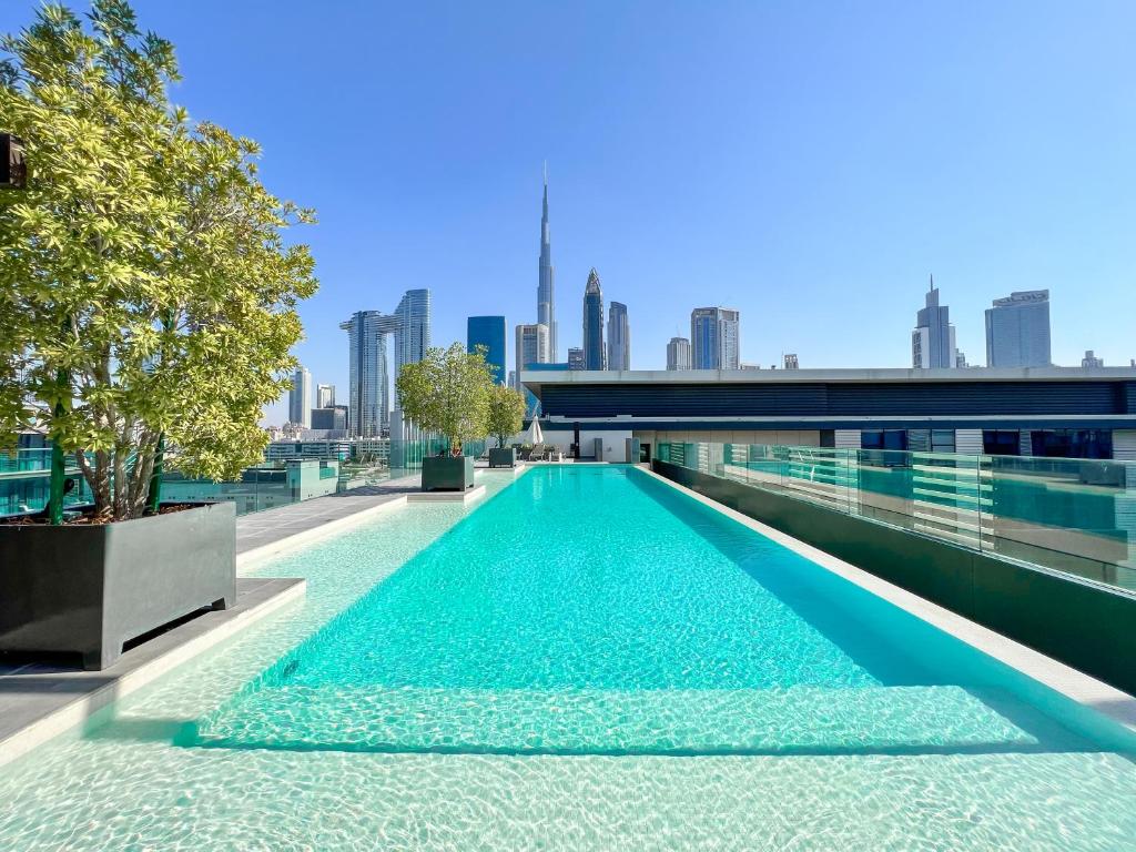 a swimming pool on the roof of a building with a city at FAM Living - City Walk - Luxe Interiors in Dubai