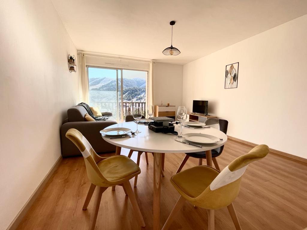 uma sala de estar com uma mesa branca e cadeiras em U061 - Grand studio rénové - Vue montagne em Gréolières