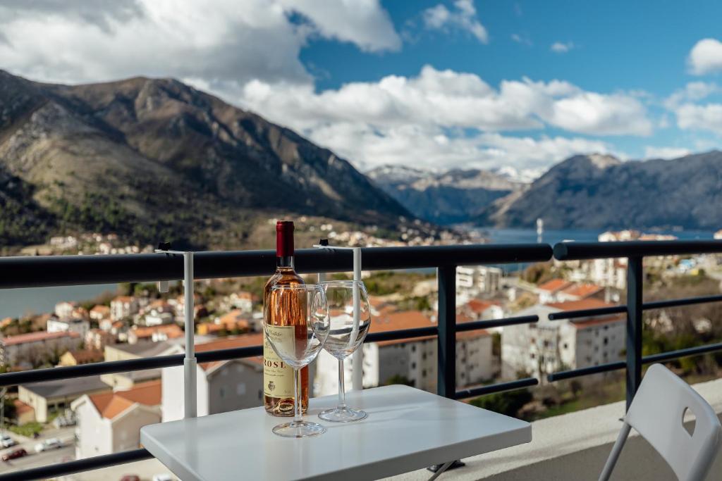 een fles wijn en twee glazen op een tafel bij LANA Sea View Apartment in Kotor