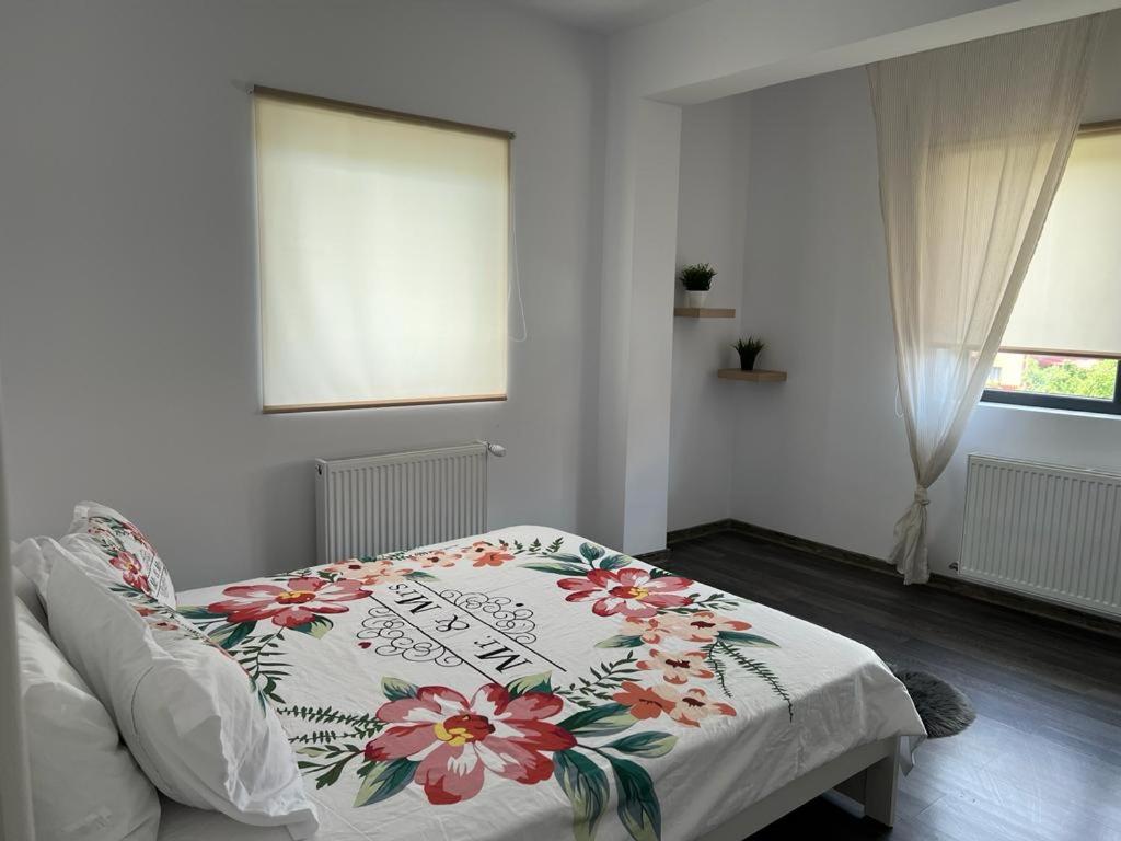 een slaapkamer met een bed met een bloemendeken erop bij DD Residence in Otopeni