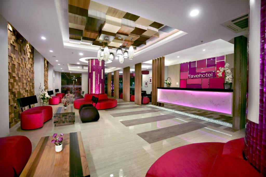 a lobby with red furniture and a pink wall at favehotel Langko Mataram - Lombok in Mataram