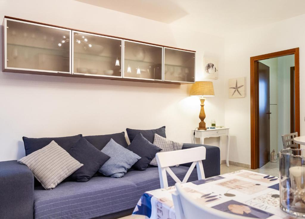 sala de estar con sofá azul y mesa en Casa Erika, en Puntone di Scarlino