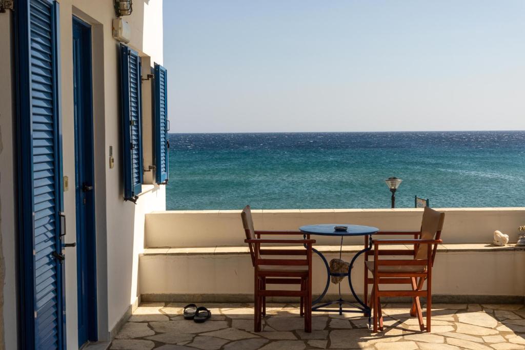 a table and chairs on a balcony with the ocean at Fabio Studios in Kionia