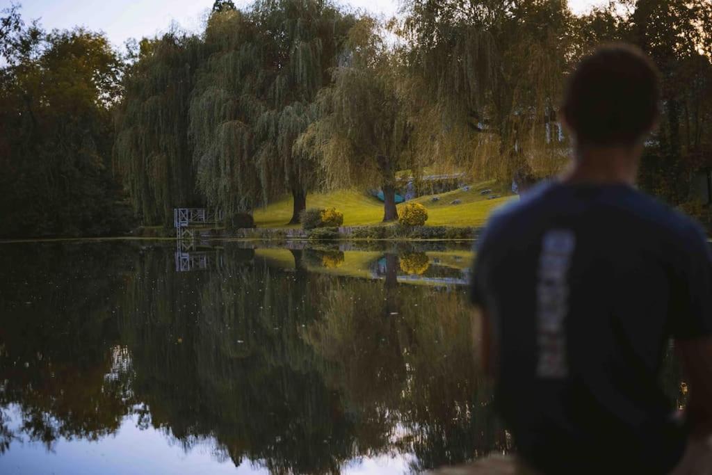 een man die voor een lichaam van water staat bij Le chalet du bout du monde, en bord de rivière ! in Grez-sur-Loing