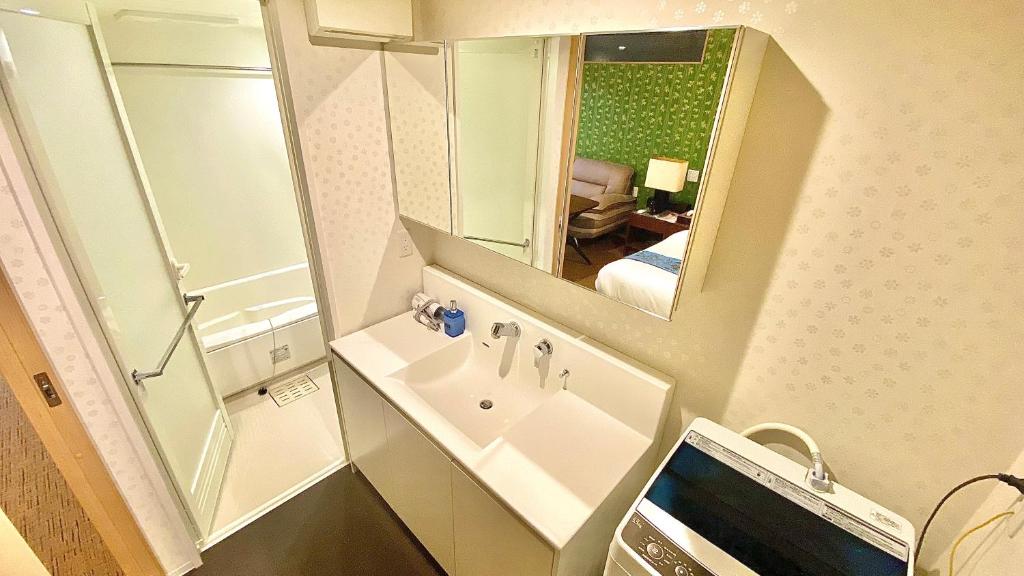 a bathroom with a sink and a mirror at One More Heart Fushimi Inari in Momoyama-chō