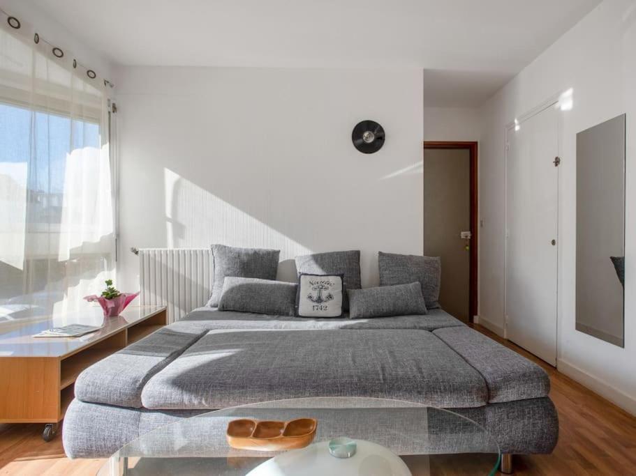 a bedroom with a large bed and a large window at Proche du port avec balcon - Kerlaouen in Vannes