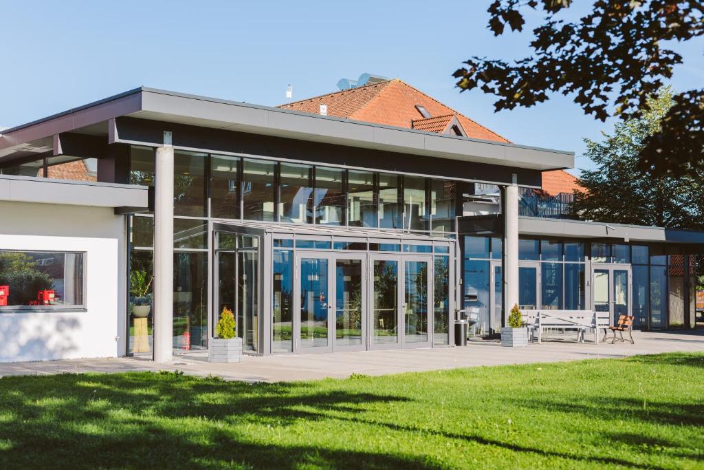 un edificio con porte in vetro e un prato di Tagungszentrum Blaubeuren a Blaubeuren