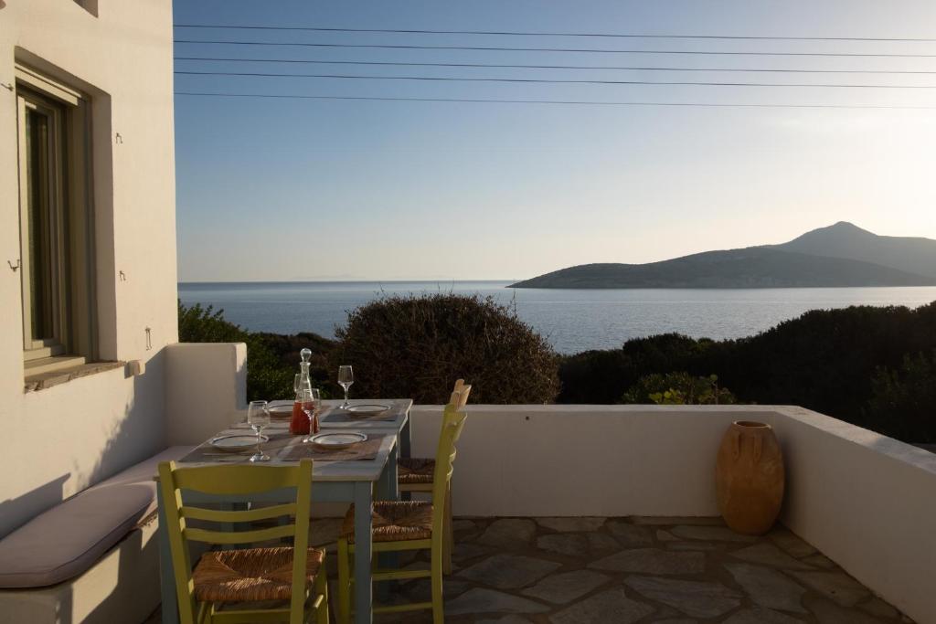 a table and chairs on a balcony with a view of the ocean at Armira seaside house in Antiparos