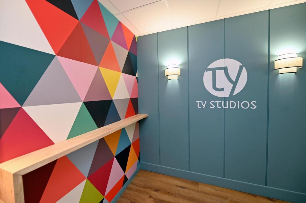 een kleurrijke muur in een kamer met een tv studio bord op de muur bij TY STUDIOS Hyper Centre Ville in Brest
