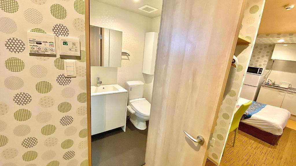a small bathroom with a toilet and a sink at One More Heart Fushimi Inari in Momoyama-chō