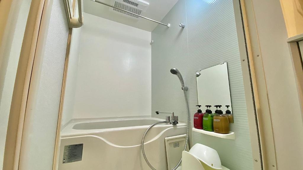 a small bathroom with a shower and a sink at One More Heart Fushimi Inari in Momoyama-chō